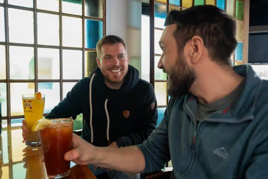 Deux hommes buvant une bière et un cocktail chez BoulZeye