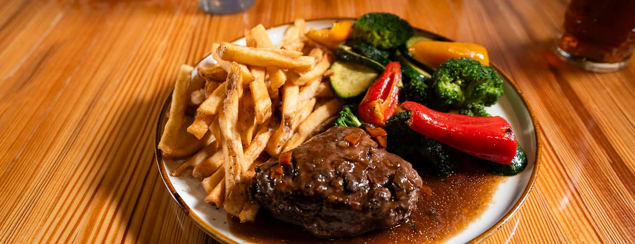 Une assiette de steak avec frite et légumes grillées