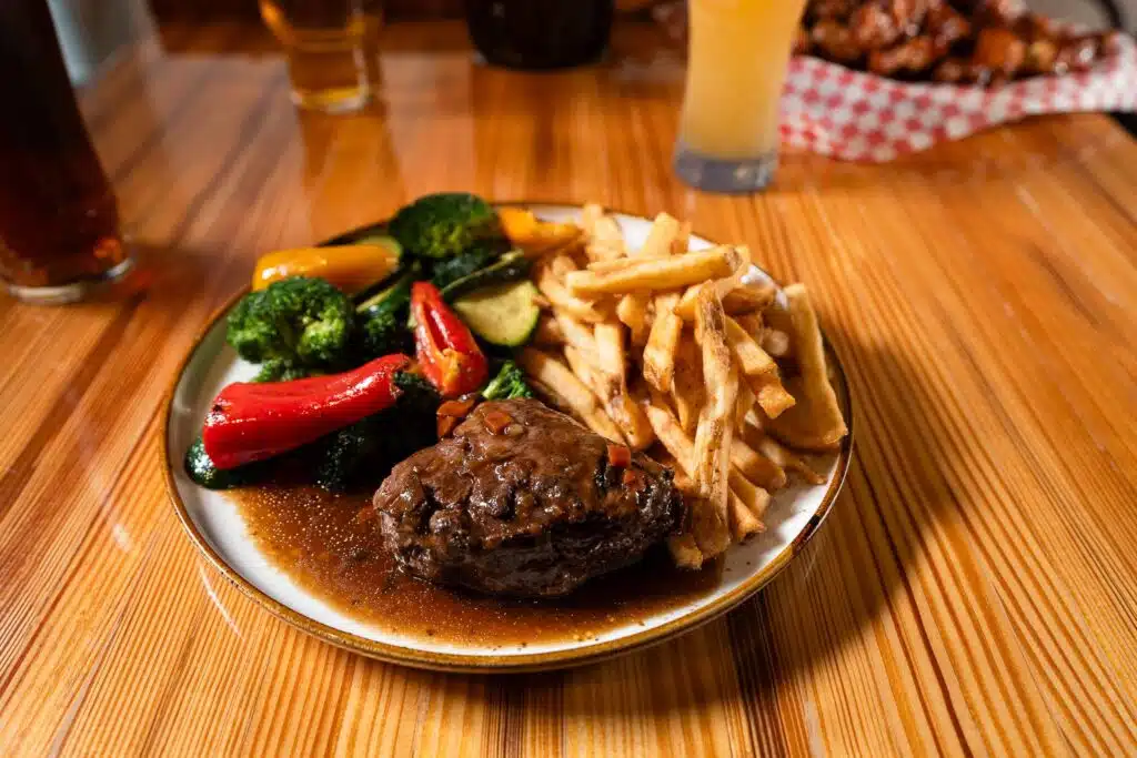 Une assiette de steak avec frite et légumes grillées