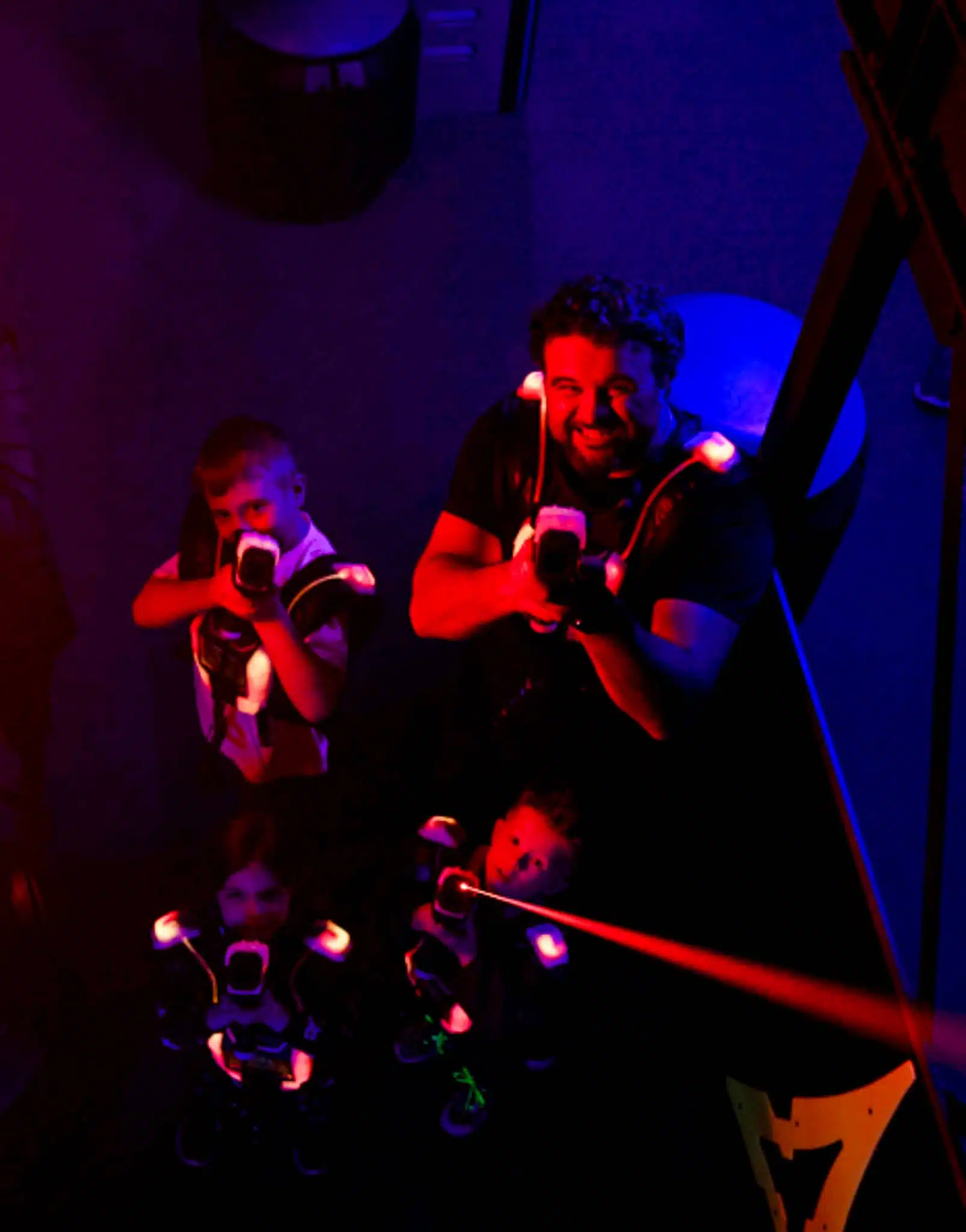 Un groupe jouant au lasertag visant la caméra